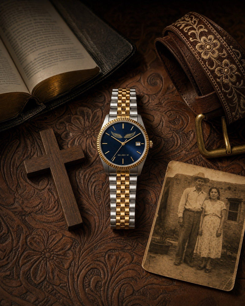 An open Bible with gold edges beside a two-tone watch on tooled leather
